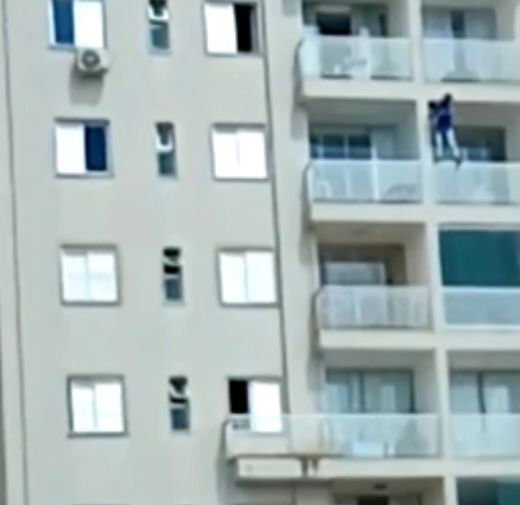 Homem fica em pé na grade de sacada do nono andar